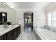 Spacious bathroom boasts dual sink vanity, separate soaking tub, and a seamless transition into the living area at 16376 Stonefeld Pl, Parker, CO 80134