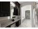 Bathroom featuring marble floors, dark cabinets, granite counters, a bathtub, and a glass shower at 16376 Stonefeld Pl, Parker, CO 80134