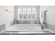 Relaxing bathtub with tile surround and window, perfect for unwinding after a long day at 16376 Stonefeld Pl, Parker, CO 80134