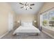 Bright bedroom with neutral carpeting, a ceiling fan, and a large window with outside views at 16376 Stonefeld Pl, Parker, CO 80134