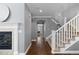 Inviting hallway featuring hardwood floors, a staircase, and a view of the living room with a fireplace at 16376 Stonefeld Pl, Parker, CO 80134
