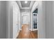 Bright hallway with hardwood floors, white doors, and recessed lighting, leading to the front door at 16376 Stonefeld Pl, Parker, CO 80134