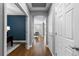 Hallway with hardwood floors, leading to a living room and an office space, with white doors at 16376 Stonefeld Pl, Parker, CO 80134