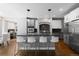 Modern kitchen with a large island with seating, stainless steel appliances, and hardwood floors at 16376 Stonefeld Pl, Parker, CO 80134