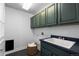 Well-organized laundry room with ample cabinet space and a deep sink, perfect for everyday tasks at 16376 Stonefeld Pl, Parker, CO 80134