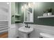 Charming powder room features a pedestal sink, decorative mirror, and stylish green paint at 16376 Stonefeld Pl, Parker, CO 80134