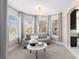 Cozy sitting area with a chandelier, marble table, and ample natural light from surrounding windows at 16376 Stonefeld Pl, Parker, CO 80134