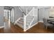 Carpeted staircase with white banisters and hardwood floors, adjacent to a dining area at 16376 Stonefeld Pl, Parker, CO 80134