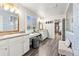 Bright bathroom featuring double vanity, tiled floors, and a separate shower and vanity space at 17335 W 94Th Ave, Arvada, CO 80007
