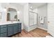 Bright bathroom featuring a modern vanity, mirror, and a glass-enclosed shower at 17335 W 94Th Ave, Arvada, CO 80007