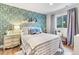 Charming bedroom with patterned wallpaper and comfortable bedding with plenty of natural light at 17335 W 94Th Ave, Arvada, CO 80007