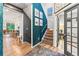 Stylish entryway with hardwood floors, patterned wall, staircase, and views into the dining and living rooms at 17335 W 94Th Ave, Arvada, CO 80007