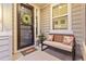 Inviting front porch with 'hello' door mat, wreath, bench with pillows, and a lovely potted plant at 17335 W 94Th Ave, Arvada, CO 80007