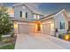 Attractive three car garage with gray siding, green shutters, and enhanced outdoor lighting at 17335 W 94Th Ave, Arvada, CO 80007