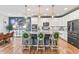 Open kitchen features an island with barstools, stainless appliances, and white cabinets at 17335 W 94Th Ave, Arvada, CO 80007
