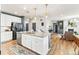 Kitchen island featuring granite countertop, white cabinets, stainless steel appliances, and hardwood floors at 17335 W 94Th Ave, Arvada, CO 80007