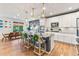 Open-concept kitchen with an eat-in island, stainless steel appliances, white cabinets, and sunset views at 17335 W 94Th Ave, Arvada, CO 80007