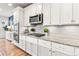 Bright kitchen with white cabinetry, granite countertops, stainless steel appliances, and tile backsplash at 17335 W 94Th Ave, Arvada, CO 80007