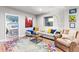 Cozy living room featuring a comfortable couch and colorful rug adjacent to a bedroom at 17335 W 94Th Ave, Arvada, CO 80007