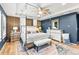 Stately main bedroom suite with four-poster bed, tray ceiling, dresser, wood accent wall, and plenty of natural light at 17335 W 94Th Ave, Arvada, CO 80007