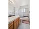 Traditional bathroom with a tiled shower, vanity, and black and white tile floors at 10378 W Weaver Ave, Littleton, CO 80127