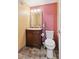 Cozy half bathroom with a pedestal sink and mosaic tile flooring at 10378 W Weaver Ave, Littleton, CO 80127