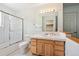 Clean bathroom with white tile, a shower, and a wooden vanity at 10378 W Weaver Ave, Littleton, CO 80127