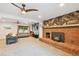 Inviting living room featuring a brick fireplace, ceiling fans, and ample natural light from the large window at 10378 W Weaver Ave, Littleton, CO 80127
