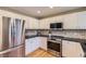 Updated kitchen featuring white cabinets, stainless steel appliances and hardwood flooring at 9680 Burberry Way, Highlands Ranch, CO 80129