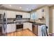 Modern kitchen features white cabinetry, stainless steel appliances, and tiled backsplash at 9680 Burberry Way, Highlands Ranch, CO 80129