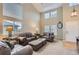 Bright living room with high ceilings, oversized windows and comfortable leather seating at 9680 Burberry Way, Highlands Ranch, CO 80129