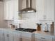 Kitchen with stainless steel range hood and white cabinets at 27750 E Lakeview Dr, Aurora, CO 80016