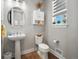 Small powder room with pedestal sink, toilet, and wood-look flooring at 27750 E Lakeview Dr, Aurora, CO 80016