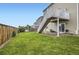 Lush backyard with a well-maintained lawn, wooden fence, and staircase leading to a deck at 942 Wagon Bend Rd, Berthoud, CO 80513
