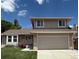 Inviting two-story home boasts a well-maintained lawn, brick accents, and attached two-car garage at 12089 W Burgundy Ave, Littleton, CO 80127