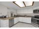 Functional kitchen featuring white cabinetry, stainless steel appliances, and tile countertops at 12089 W Burgundy Ave, Littleton, CO 80127