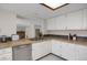 Well-lit kitchen featuring tan countertops, white cabinets, and a stainless steel dishwasher at 12089 W Burgundy Ave, Littleton, CO 80127