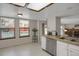 Sunlit kitchen with stainless steel dishwasher and sink area, complemented by an eat-in area at 12089 W Burgundy Ave, Littleton, CO 80127