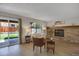 Cozy living room featuring brick fireplace, sliding glass doors to backyard, and hardwood floors at 12089 W Burgundy Ave, Littleton, CO 80127