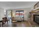 Comfortable living room with a brick fireplace, hardwood floors, and a sliding glass door to backyard at 12089 W Burgundy Ave, Littleton, CO 80127