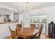 Cozy dining room features a chandelier and wood table with connection to the living room and kitchen at 5856 Simms St, Arvada, CO 80004