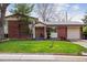 Charming brick home with an attached garage, mature trees, and a well-maintained front yard at 5856 Simms St, Arvada, CO 80004