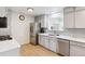 Modern kitchen features stainless steel appliances, white quartz countertops, and updated cabinets at 5856 Simms St, Arvada, CO 80004