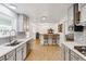 Open kitchen with light wood floors and views to the dining room. Quartz counters and stainless appliances at 5856 Simms St, Arvada, CO 80004