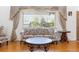Comfortable living room with hardwood floors, a large window with decorative drapes, and cozy furnishings at 5856 Simms St, Arvada, CO 80004