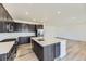 Open kitchen with dark cabinets, quartz countertops, large island, and stainless steel appliances at 24715 E Evans Dr, Aurora, CO 80018
