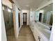 Bright bathroom featuring double sinks, modern fixtures, and a glass-enclosed shower at 25343 E Warren Pl, Aurora, CO 80018