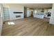 Open concept living room with wood flooring, modern fireplace, and a view of the kitchen at 25343 E Warren Pl, Aurora, CO 80018
