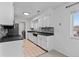 Modern kitchen with white cabinets, stainless steel appliances, and tile flooring at 9868 Appletree Pl, Thornton, CO 80260