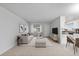 Bright living room with open concept floor plan, featuring a sofa and adjacent dining area at 9868 Appletree Pl, Thornton, CO 80260